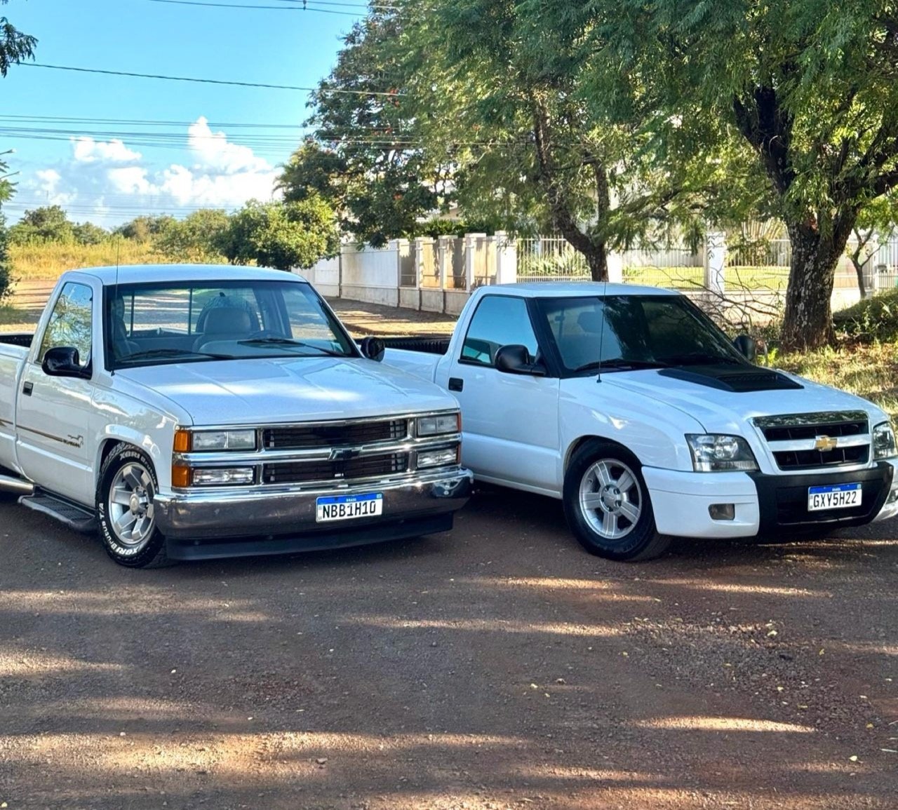 Chevrolet Silverado branca ao lado de uma S10 branca.